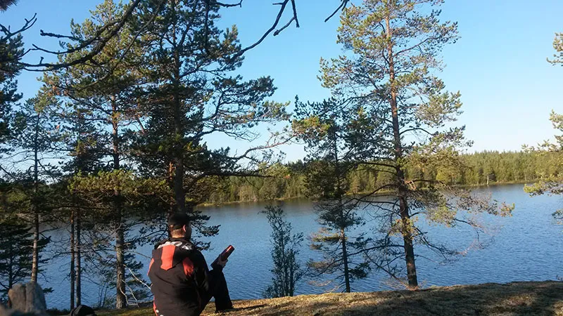 Skogssjö utanför Hertsånger, omgiven av tallar en klar dag
